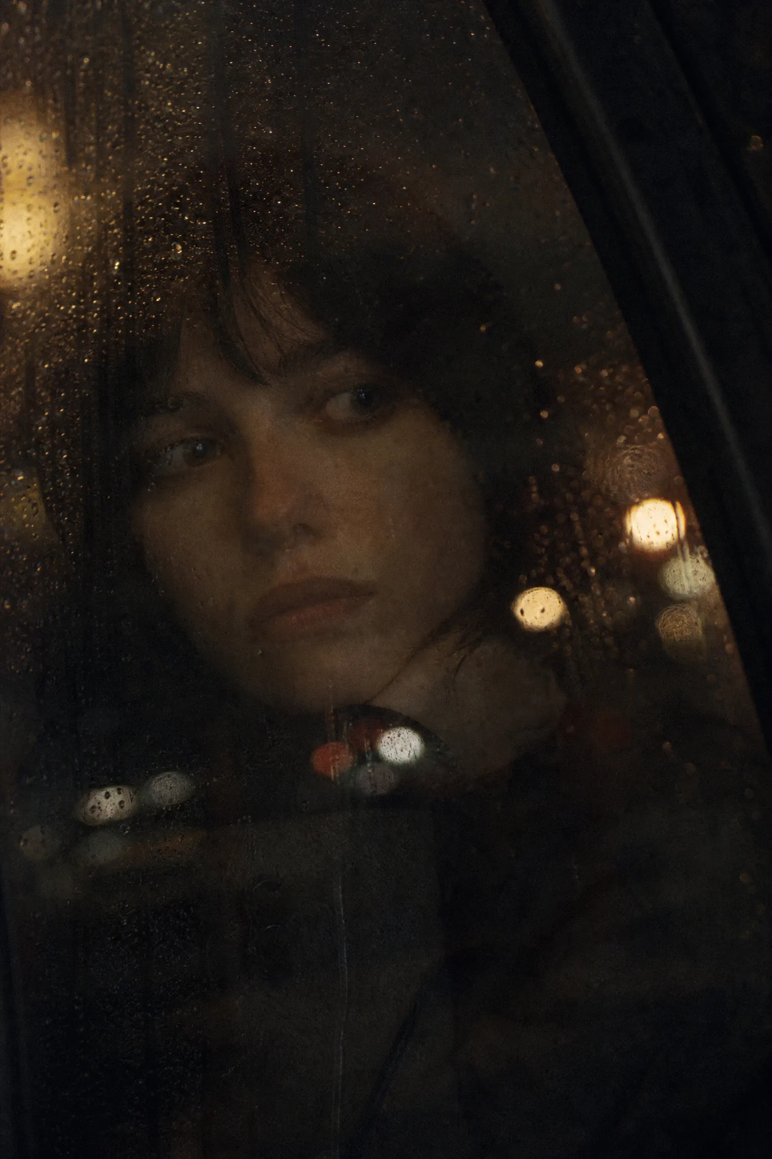 电影海报：雨夜窗前的女性面孔